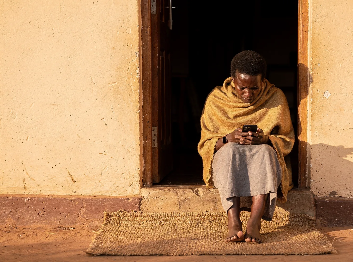 A woman reading quietly in a doorway at the end of the day