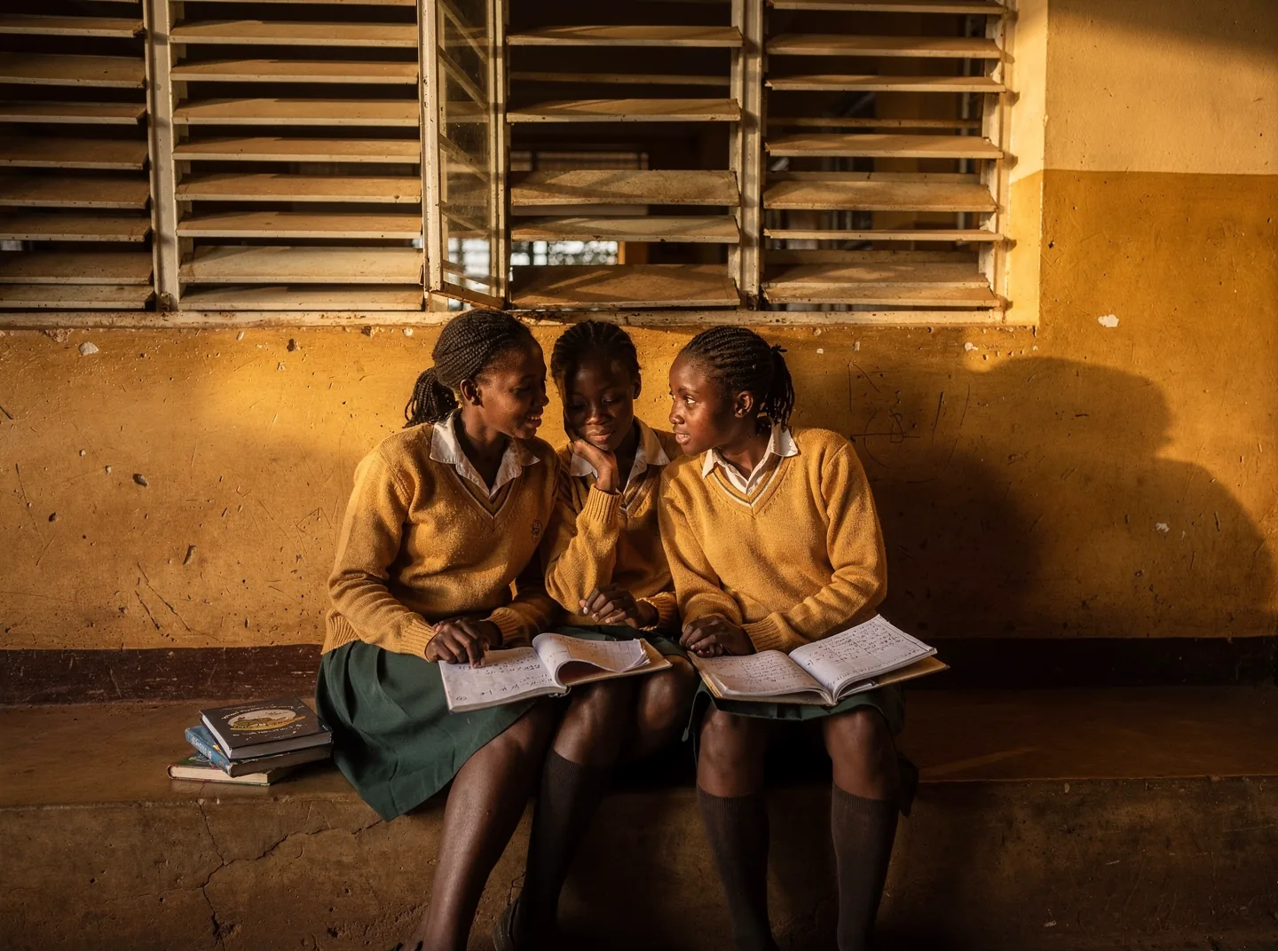 Three secondary school students working together in a corridor